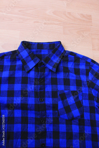 Plaid tartan shirt, blue and black colour checkered pattern. Stylish lumberjack flannel shirt close up view, shopping and fashion design clothes concept