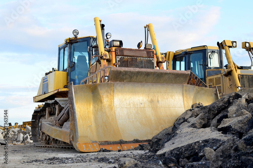 Track-type bulldozer  earth-moving equipment. Land clearing  grading  pool excavation  utility trenching  utility trenching and foundation digging during of large construction jobs.