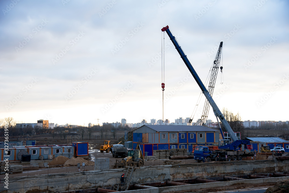 Mobile auto cranes working at construction site. Digging a pit for the building of an underground tunnel of the metro line. Subway construction project, Minsk, Belarus, Aerodromnaya street