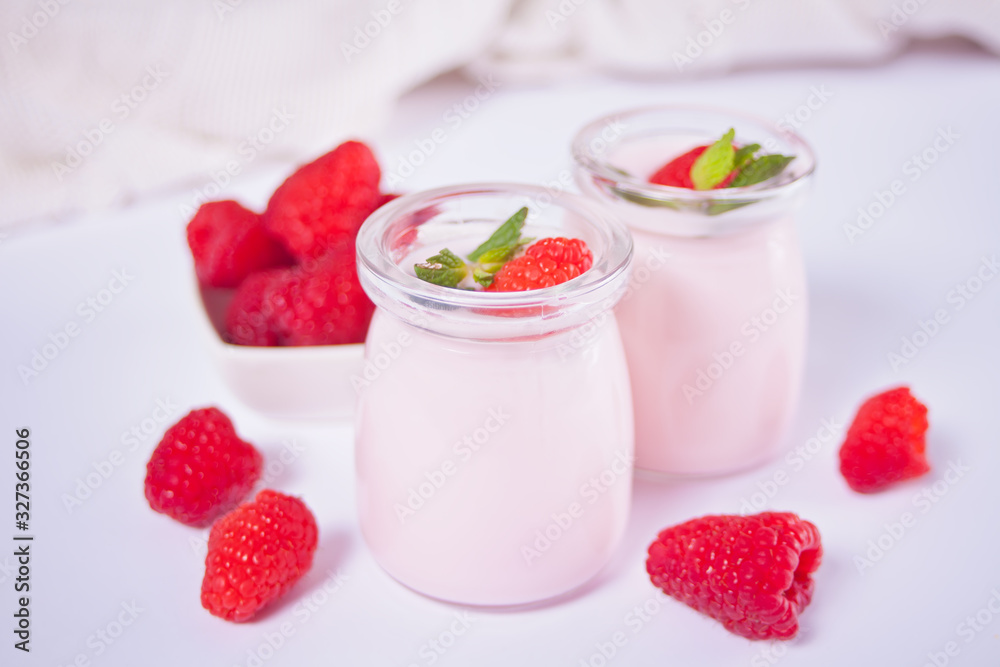 Two portions natural homemade yogurt in a glass jar with fresh raspberry. Breakfast concept. Two portions natural homemade yogurt in a glass jar with fresh raspberry. Breakfast concept.