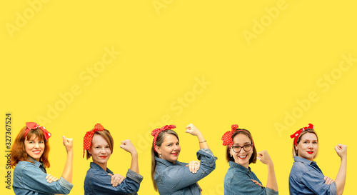 Women with a clenched fist rolling up their sleeves on yellow background, copy space, tribute to the icon Rosie Riveter. Girl power concept. Women's day. photo