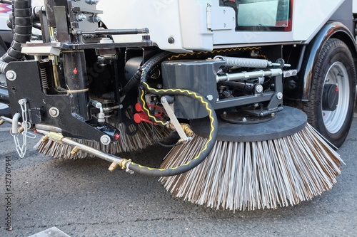 Sweeping equipment for routine year-round municipal street and highway sweeping.Big round brushes of street sweeper with wide sweeping path close up.Urban street cleaning.All seasons cleaning machine.