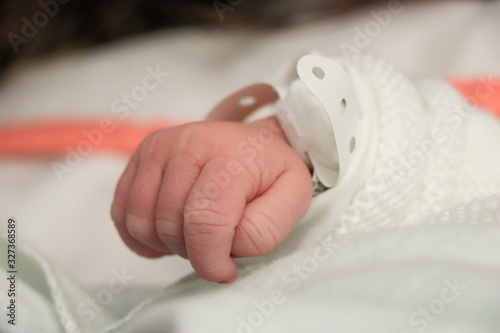 Little hand detail from a Newborn baby in bed. New born child sleeping