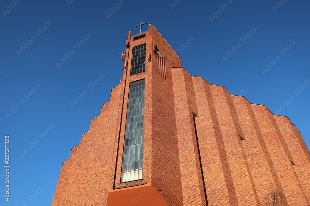 Red bricks made catholic church against the blue sky and winter trees in Lublin Poland