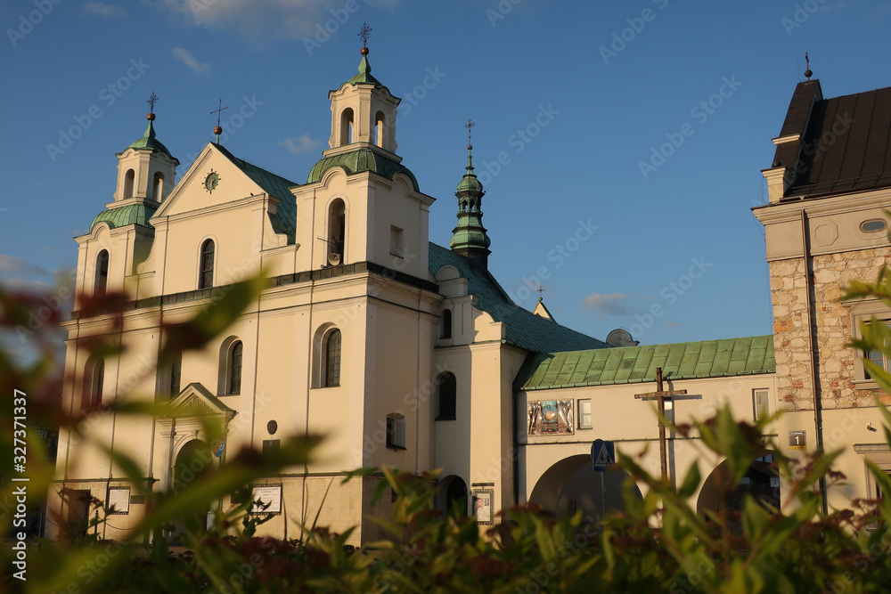 Old catholic church, blue sky and green leaves and grass