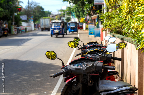 motorcycle Parking on the street of the island of Sri Lanka, street and traffic on it, Asia, Ceylon. Depth of field, focus blur