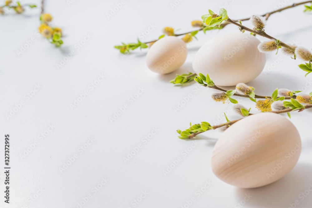 Composition with green buds on branches, easter eggs on a light background