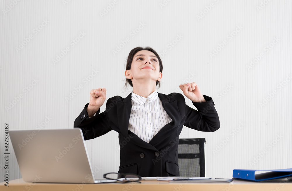 A businesswoman has taken a rest and stretching on the office chair with smiling and happiness. A businesswoman has taken a rest and stretching on the office chair with smiling and happiness.