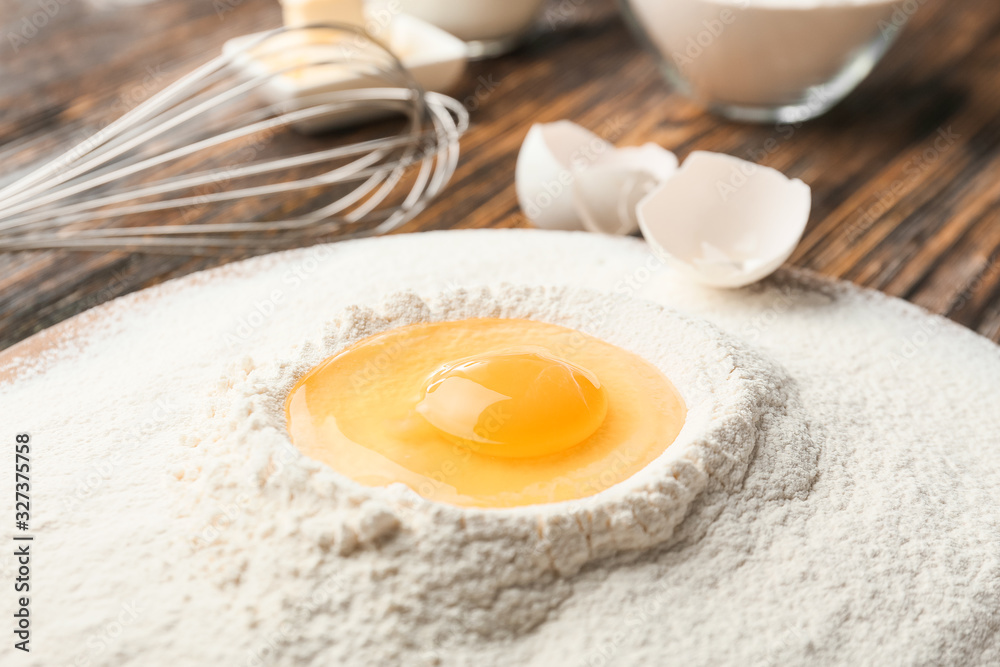 Raw egg with flour on table, closeup