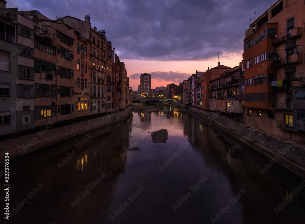View of the sunset and the old city of Girona from the bridge over the Onyar River. Catalonia. Spain.