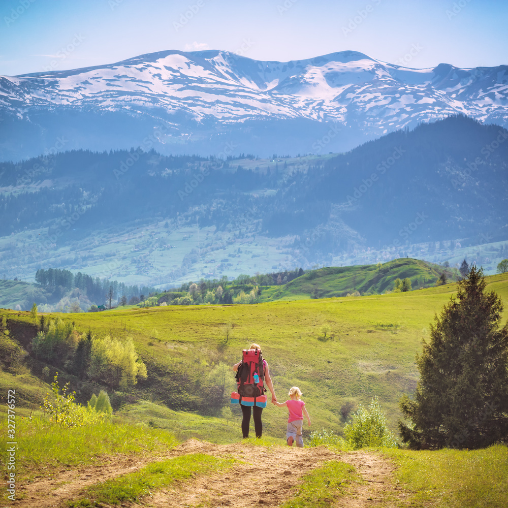 Mother hiker with her small daughter on a trekking day