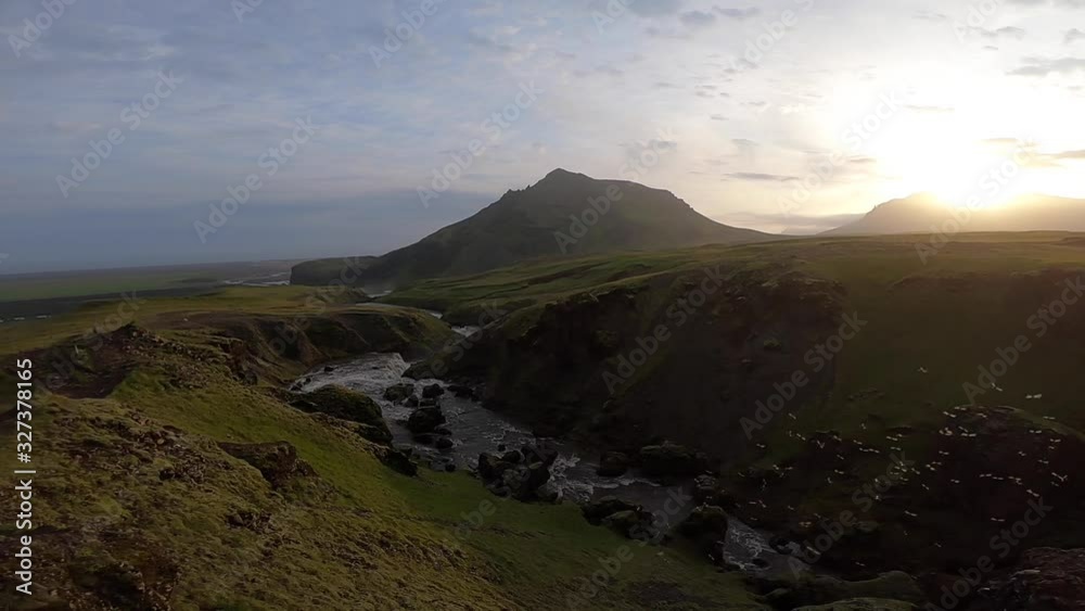 Beautiful smooth river in Iceland surrounded by green hills during the sunset on the Fimmvorduhals hiking trail close to Skogar Beautiful smooth river in Iceland surrounded by green hills during the sunset on the Fimmvorduhals hiking trail close to Skogar