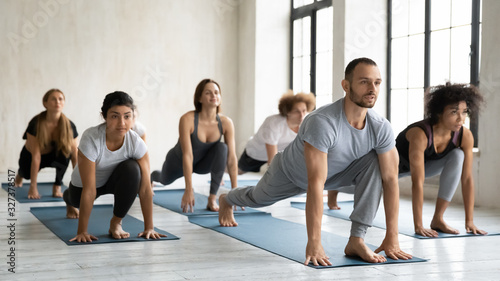 Diverse people performing Low lunge forward or Ashva Sanchalanasana indoors