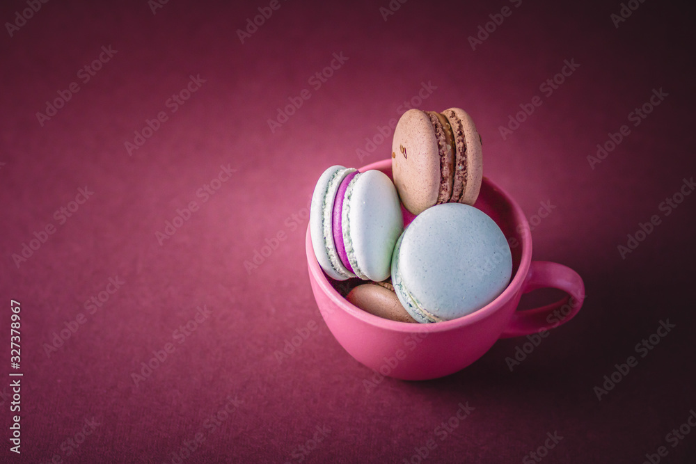 Obraz premium Selective focus of macarons field with cream in the cup. Copy space.