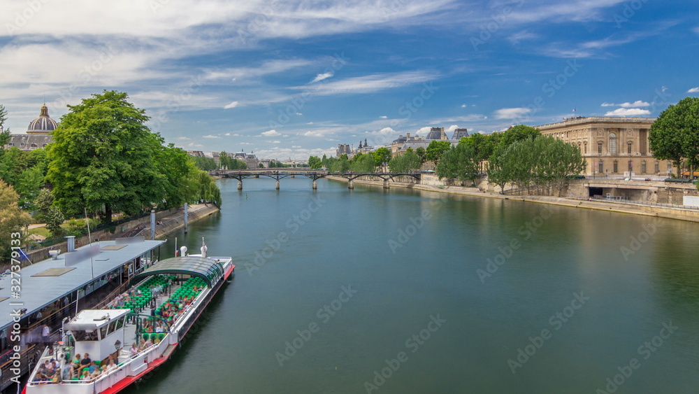 Touristic boat passes below Pont des Arts and stop on boat station on Seine river timelapse  in Paris.