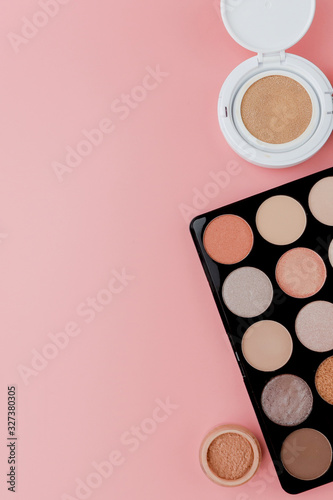 Makeup products on pink background. Top view with copy space