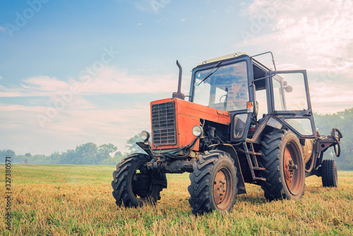 old tractor fertilizes in the field in a nice blue sunny day