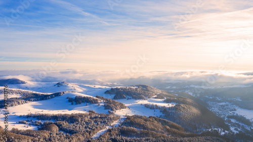 Aerial view of a gold sunset over winter snow.