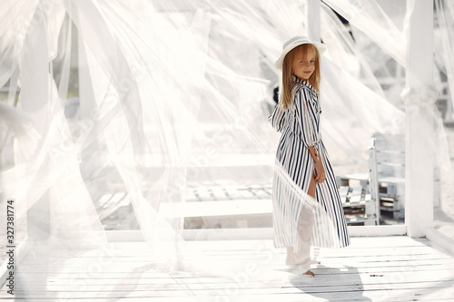 Child in a plase with white background. Girl in a strip dress. photo