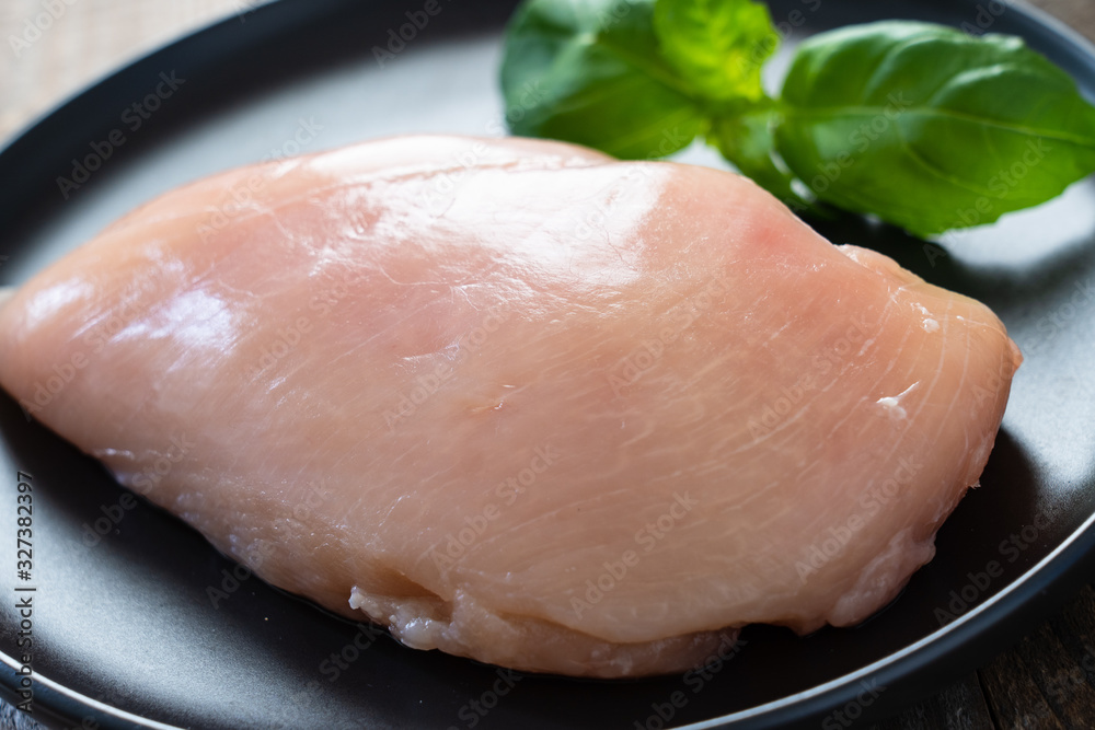 Raw chicken breasts with spices on wooden background Raw chicken breasts with spices on wooden background