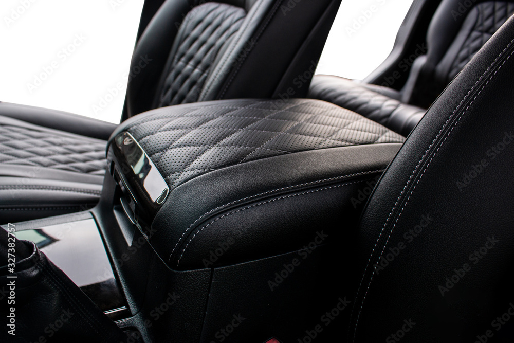 inter-seat armrest tucked in perforated leather and stitched in diamonds