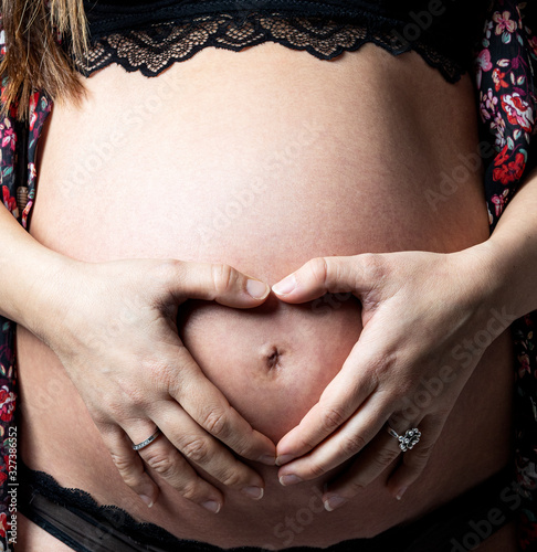 Pregnant woman with heart shaped hands