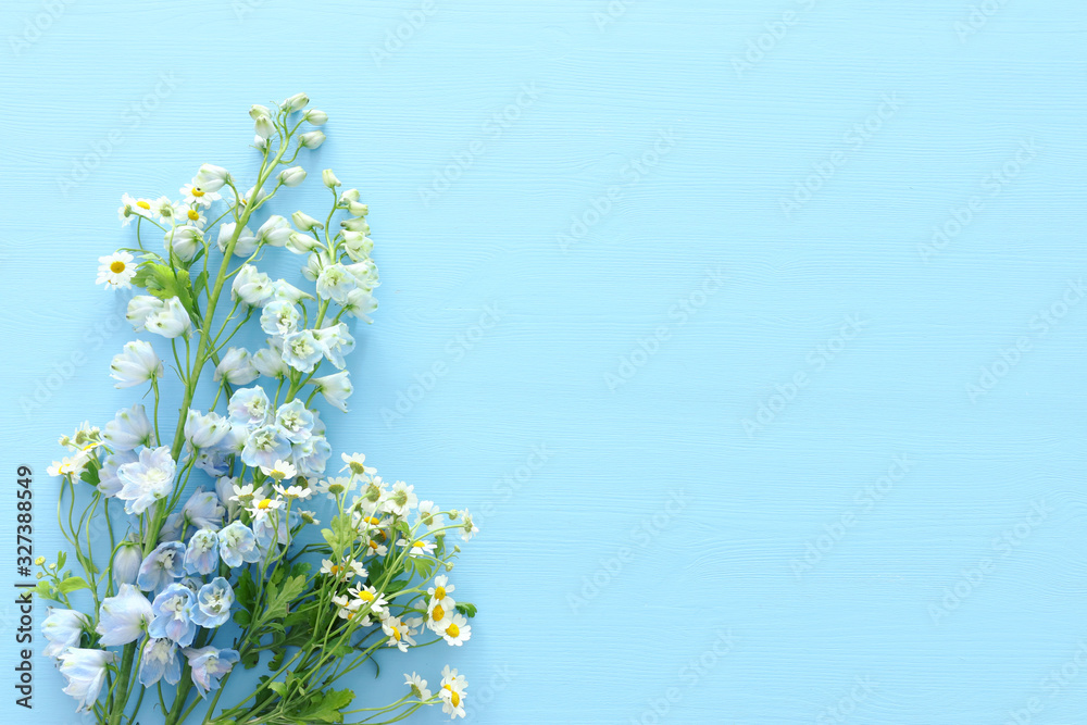 spring bouquet of white and blue flowers over blue wooden background. top view, flat lay spring bouquet of white and blue flowers over blue wooden background. top view, flat lay