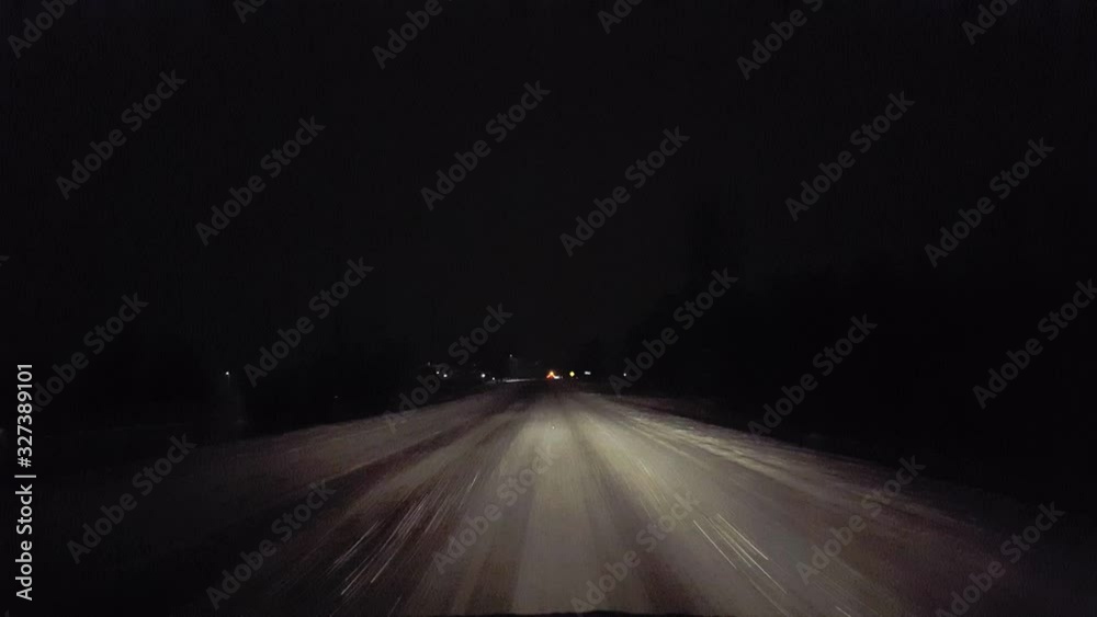 Driver Approaching Traffic Accident While Snowing on Rural Road at Night.  Driver Point of View POV Moving Toward Vehicle Collision  on Slippery Dangerous Icy Snow Street During Winter in the Evening.