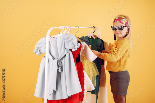 Child with shopping bags. Lady in a yellow sweater. Little designer