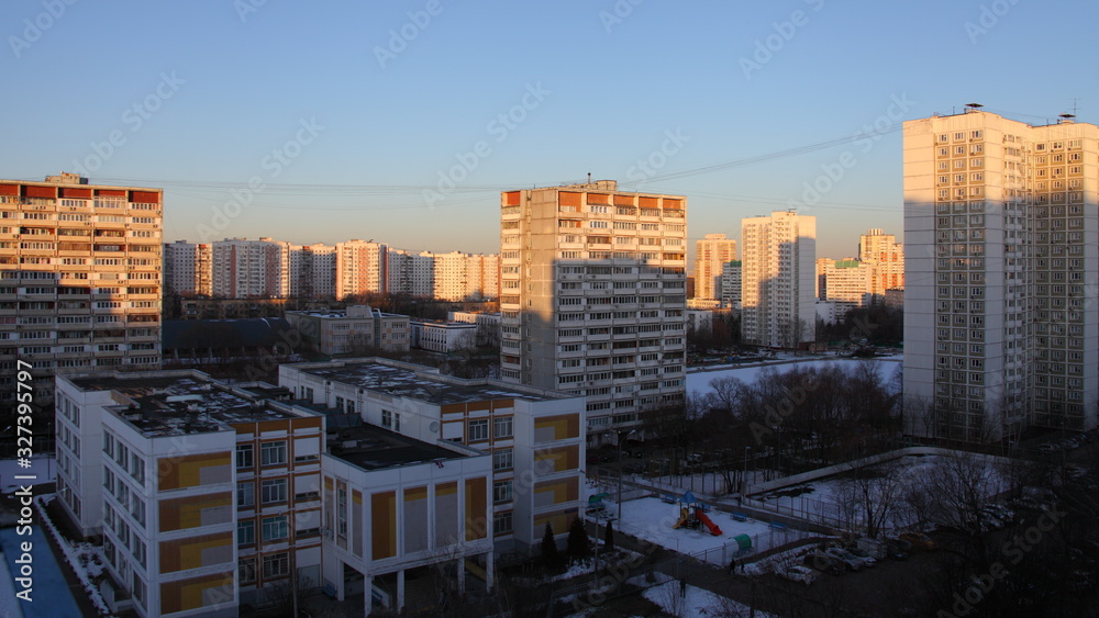 Scool and multi-storey residential buildings with in the Moscow district of Konkovo on a winter morning in the sun rays