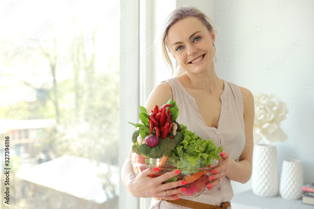 young positive smiling woman with vegetables in the kitchen young positive smiling woman with vegetables in the kitchen