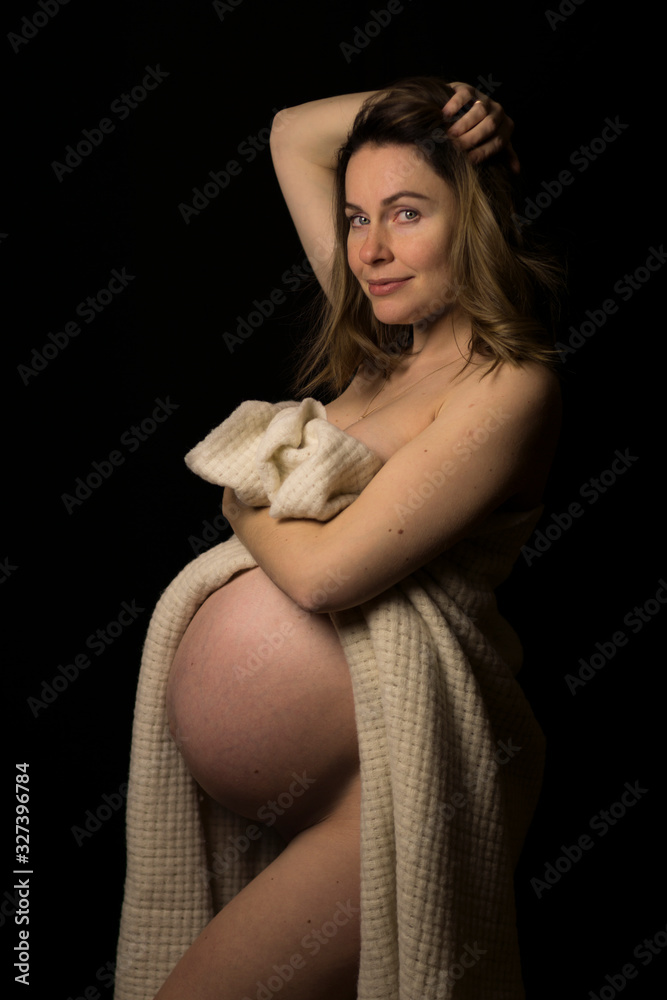 Sexy half naked pregnant white woman in ninth month of pregnancy