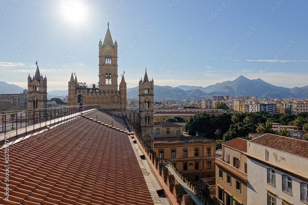 The bell tower and the roof of Palermo Cathedral with mountains at golden hour