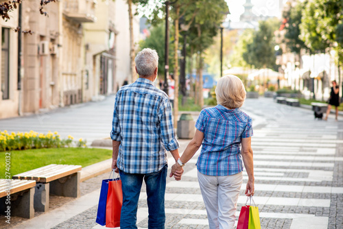 Senior couple with shopping bags walking after shopping