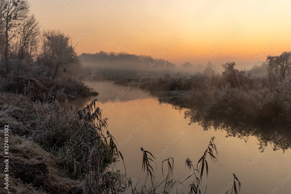 A beautiful sunrise over the misty river.