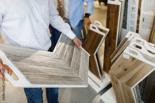 Fotografía Close up photo, man choosing wooden tiles for their house repairment in the buil