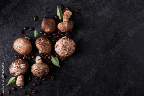 Shiitake mushrooms with coffee beans on a dark background. Top view. Coffee with mushrooms - superfood trend.