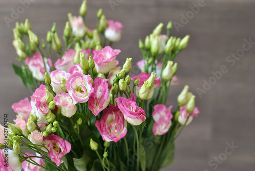 Beautiful lush bouquet of pink flowers on the wooden background. Stylish floristic composition closeup view picture. Spring time and holidays concept, interiors decorating