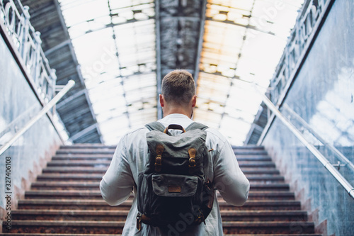 traveler man with backpack walking up by stairs