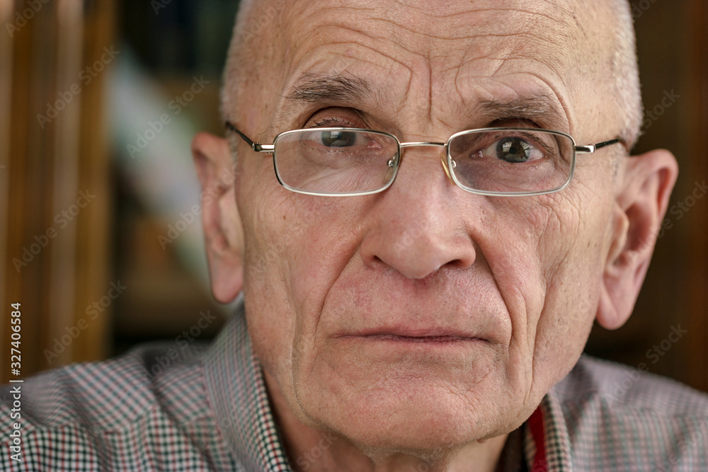 man with wrinkles on face on blurred background at home man with wrinkles on face on blurred background at home