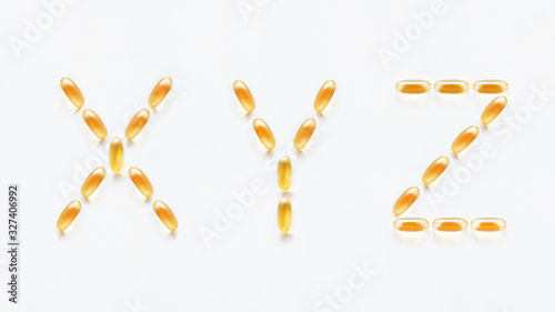 Letters X, Y, Z made of transparent yellow pills. Part 9 of latin alphabet in medical style. Isolated on white background.