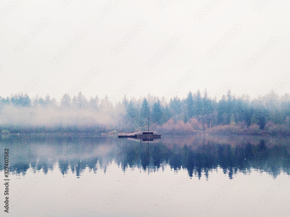 A reflection foggy scene of Lost Lagoon with forest on the background in Stanley Park, British Columbia, Canada A reflection foggy scene of Lost Lagoon with forest on the background in Stanley Park, British Columbia, Canada