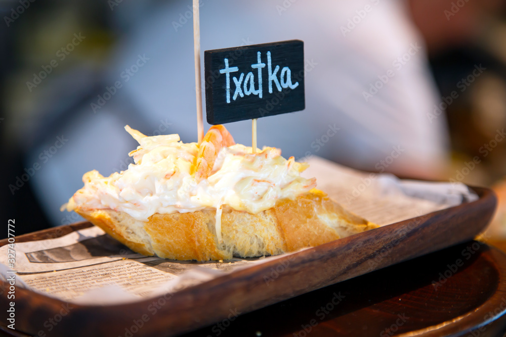 Fototapeta premium Appetizing pinchos with crab salad and shrimp close-up in the restaurant of San Sebastian, Donostia, Spain