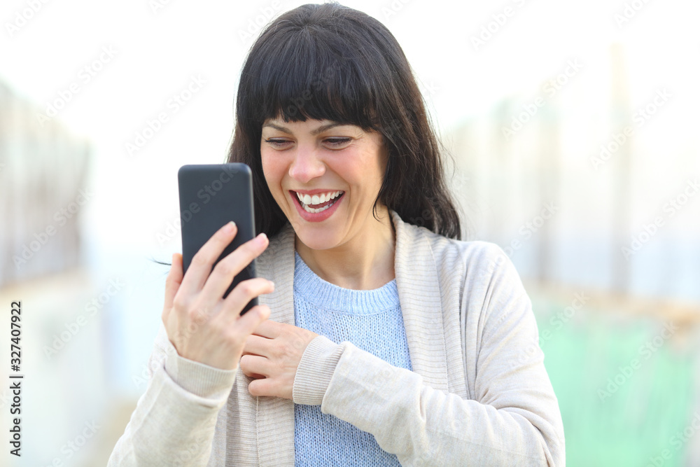 Adult woman laughing checking smart phone content Adult woman laughing checking smart phone content