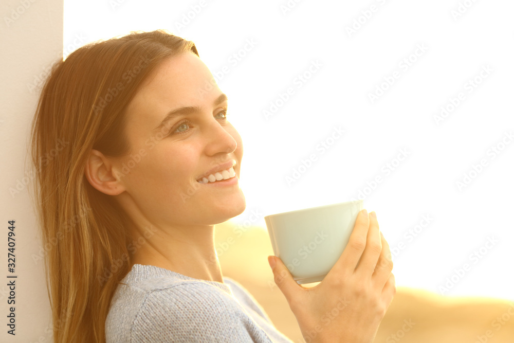 Happy woman dreaming drinking coffee at sunset Happy woman dreaming drinking coffee at sunset
