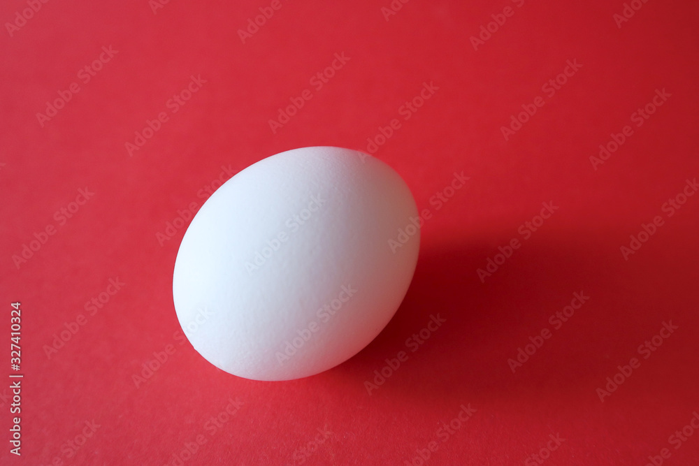 White egg lie on a red background. Happy easter concept.