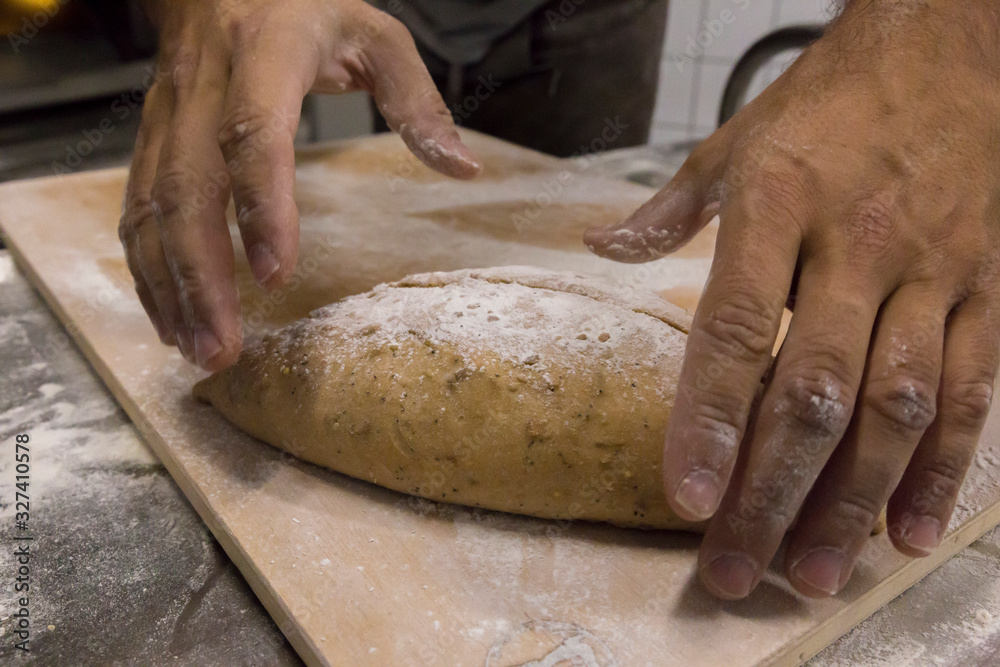 Working a raw bread loaf before entering it in the oven