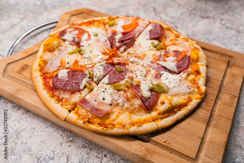 Homemade pizza With pepperoni and cheese on a wooden cutting Board on the table closeup
