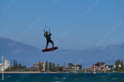 Kitesurfer in wetsuit in  the jump on a background of high mountains