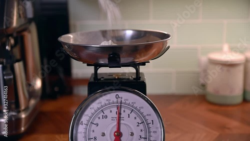 flower porred onto kitchen weighing scales photo